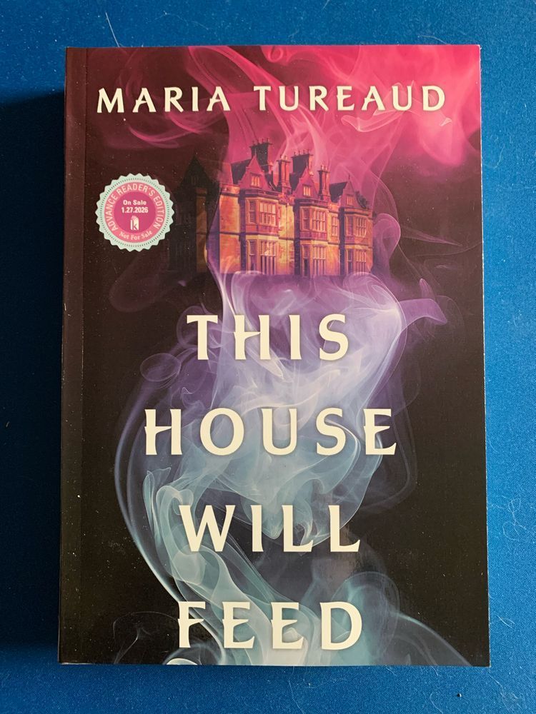 book cover for this house will feed by marie tureaud with white lettering over a dark background showing a manor house in a dramatic curl of smoke that turns pinkish near the top 