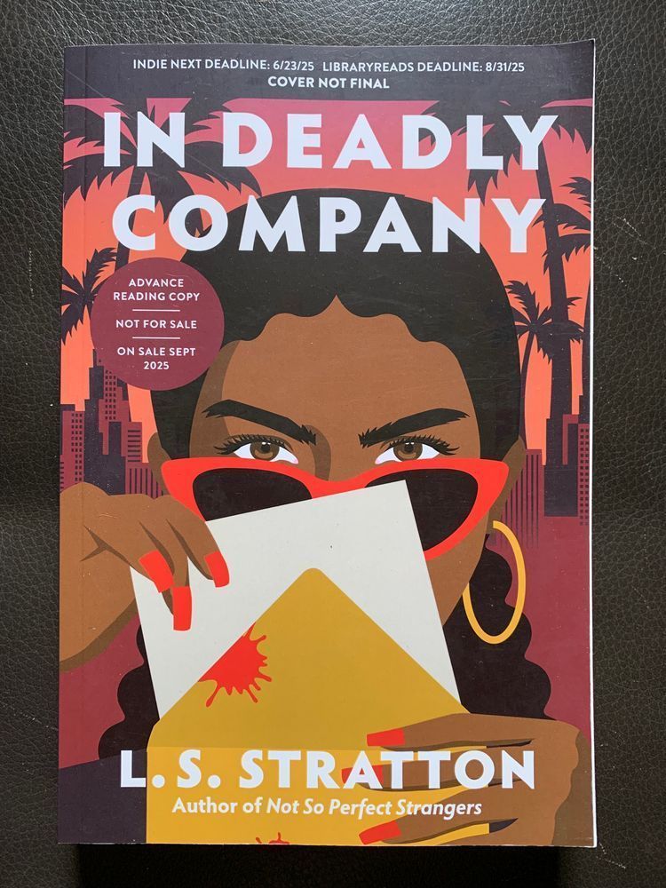 book cover for in deadly company by l. s. stratton with white lettering over a cartoon style illustration of a dark skinned woman peering over a set of red cat eye sunglasses as she draws a card out of a blood spattered envelope with fingernails painted to match her glasses. a city skyline and palm trees are in the background