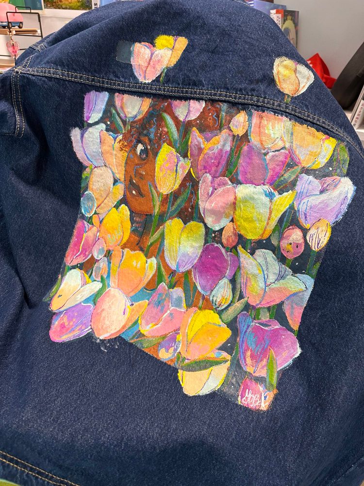 Work in Progress painting on the back of a chore jacket. A lady hiding in tulips