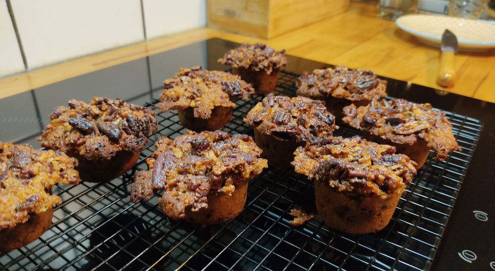 Une dizaine de gâteaux recouverts de noix de pécan sur une grille a pâtisserie