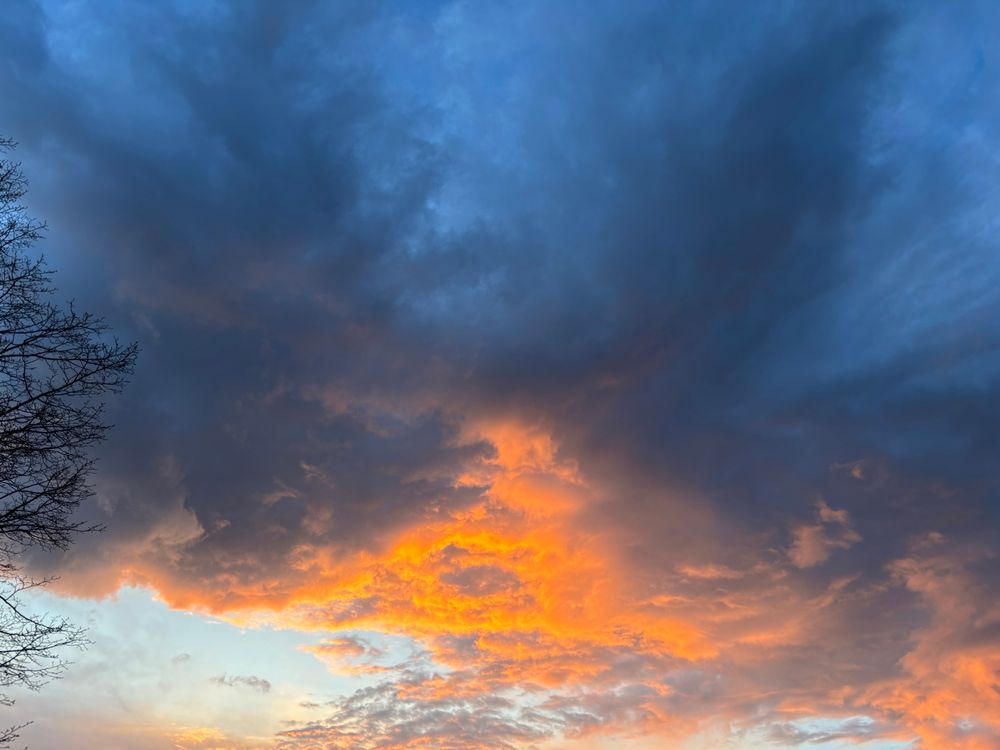 This sunset is under lit fire orange clouds with two dark plumes of clouds rising above. I think it looks a little demonic, but maybe that says more about me than the image. Beautiful.