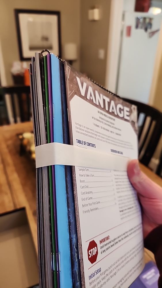 Side profile of a stack of thin books from the board game "Vantage". Probably a few inches thick.