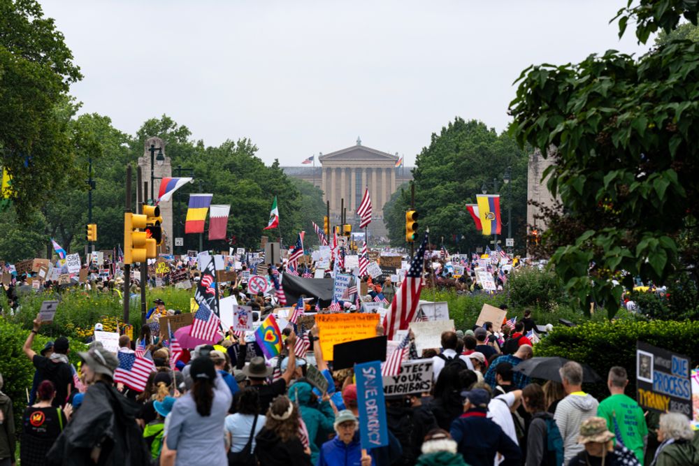 Marchers moving down Benjamin Franklin Parkway with the destination, the Philadelphia Museum of Art in the middle distance.