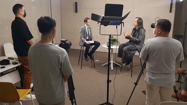 Audrey Tang (second right), Taiwan's cyber ambassador and 1st digital minister, is interviewed by Alec MacDonald (third left) of TaiwanPlus News for a Zoom In Zoom Out segment set to air in July 2025.