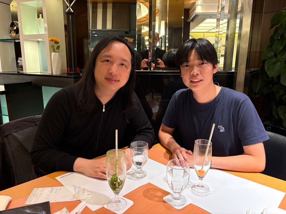 Audrey Tang (left), Taiwan's cyber ambassador and first digital minister, is seated at a cafe table with Koh Nasu (right), reverse mentor and high-school student, in Tokyo, Japan.
