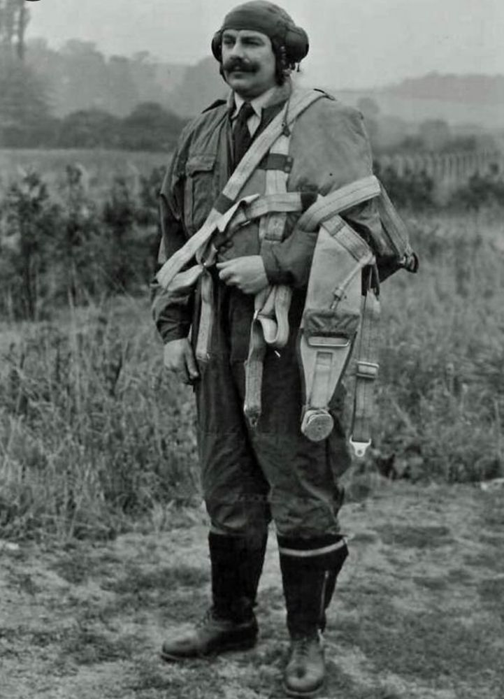 Bernard Lynch BEM, in his helmet and flying suit, which covers his suit and tie.
