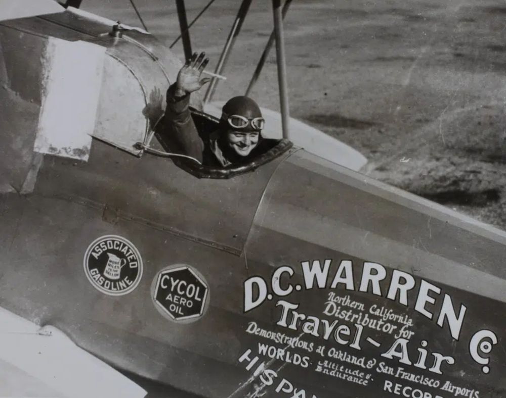 Louise Thaden waves from the cockpit of the Travel Air 3000, NC5426. The forward cockpit has been modified to accept a large auxiliary fuel tank. Image: San Diego Air & Space Museum