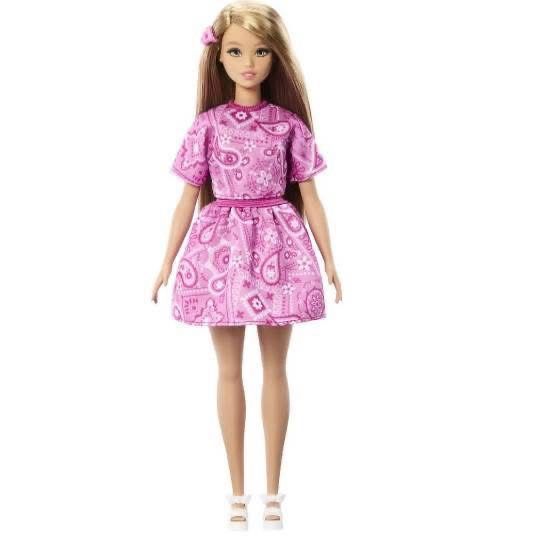 full body of the doll. i think she’s the curvy body. she’s wearing a matching pink skirt to the shirt, and white platform sandals 