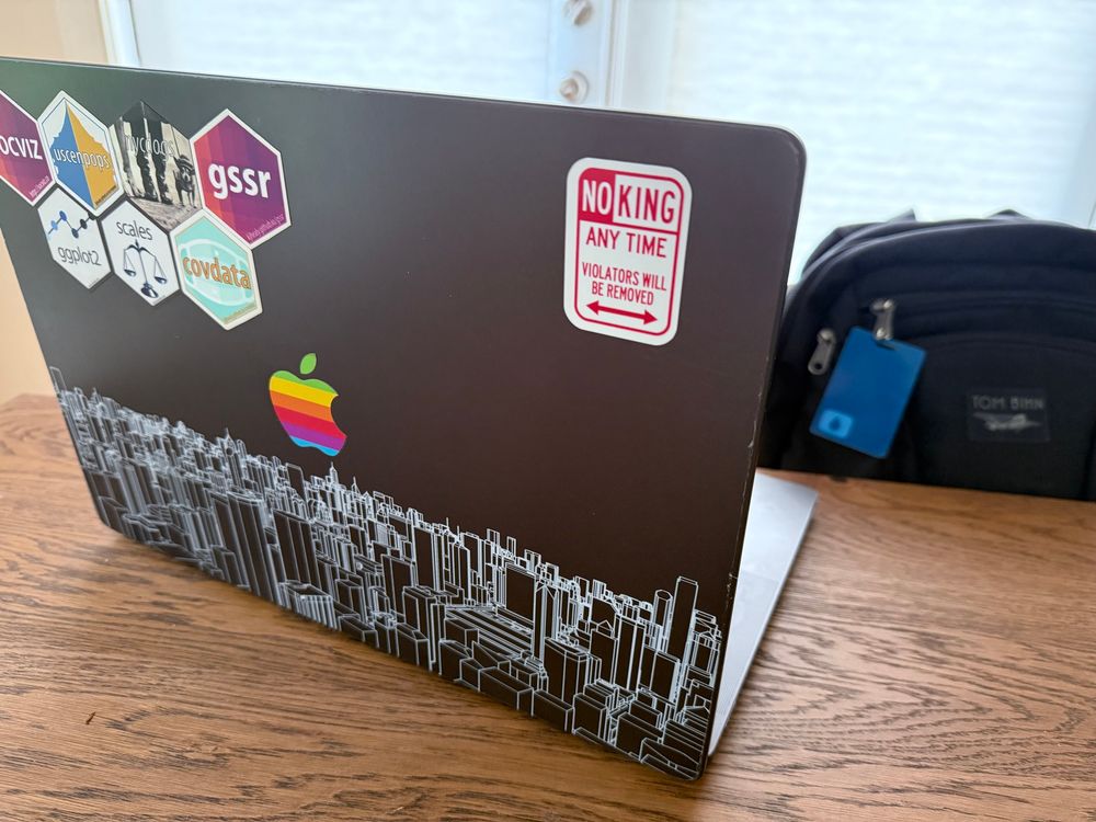 Laptop with “NO KING ANY TIME” sticker in the style of a street no parking sign 