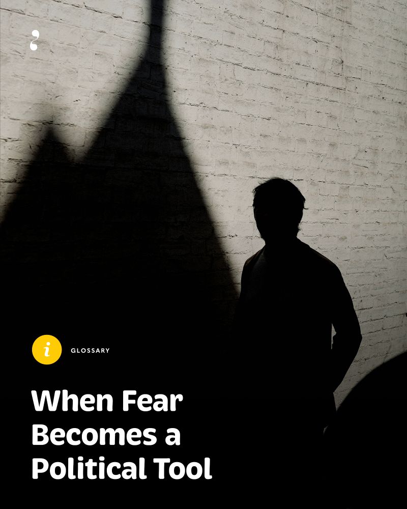 Silhouette of a person standing against a sunlit brick wall, with a sharp triangular shadow stretching upward, cast by an unseen structure. Photo credit: Clem Onojeghuo/Unsplash.