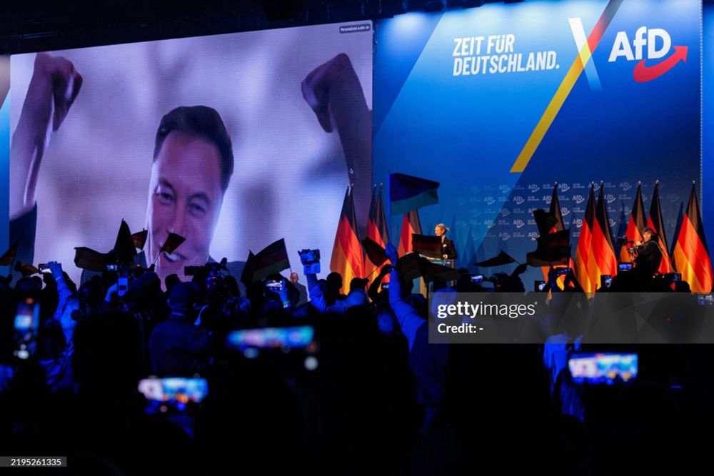 US tech billionaire and businessman Elon Musk (L) is seen on a large screen as Alice Weidel, co-leader of Germany's far-right Alternative for Germany (AfD) party, addresses an election campaign rally in Halle, eastern Germany on January 25, 2025. (Photo by AFP) (Photo by -/AFP via Getty Images)