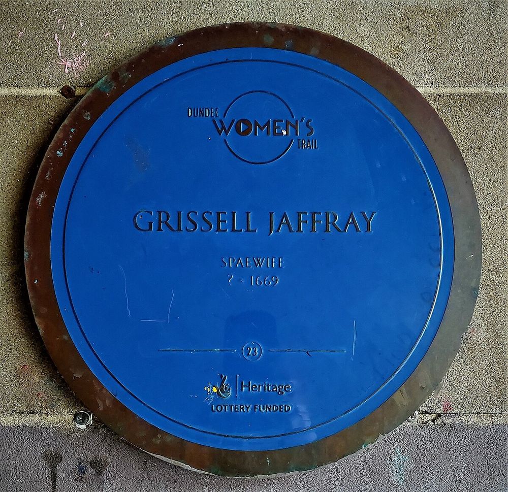 A circular blue plaque on the wall, reading 'Grissell Jaffray, Spaewife, ? to 1669'. 