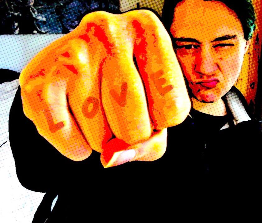 photo middle-aged, white woman making a pseudo tough face, fist forward with LOVE spelled out on the fingers. Comics image filter.