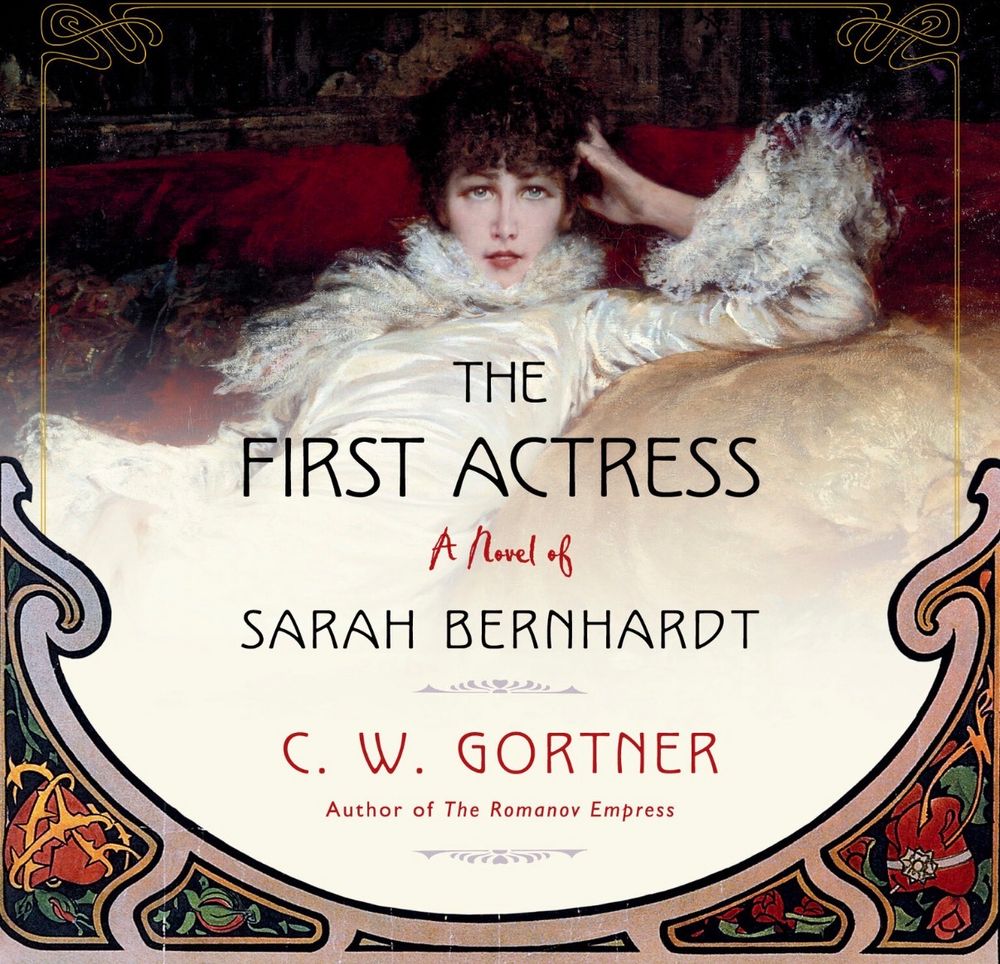 Cover for the book “The first actress“ which shows the actress Sarah Bernhardt in a portrait by Georges Clairin from 1876. Bernhardt is lounging in a fabulous white dress, gazing directly at the viewer.
