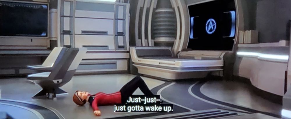 VADM Janeway is lying on the floor. Text: Just-just- just gotta wake up.
