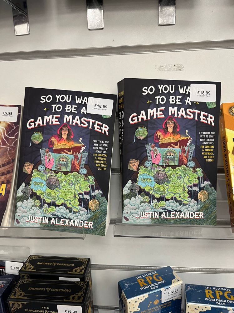 Two ‘So You Want To Be A Game Master’ softcover books on the shelf of Forbidden Planet, Birmingham, UK