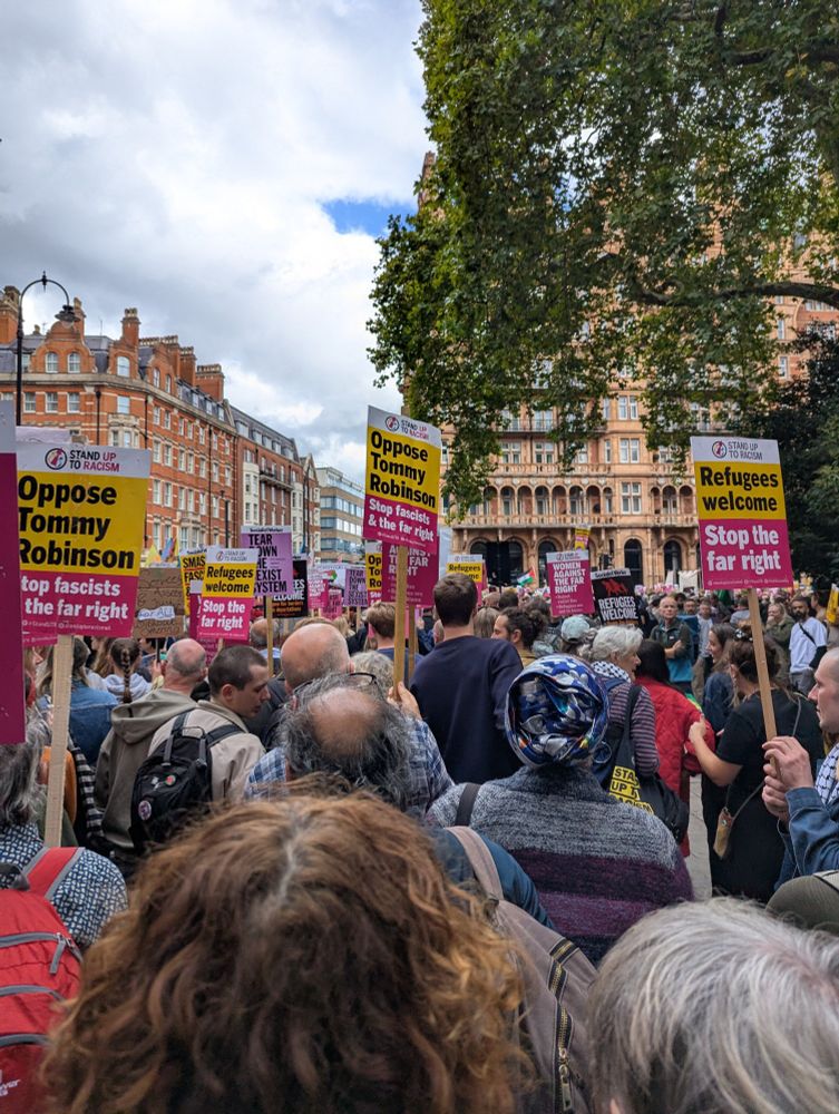 Hundreds of people waiting to turn onto Southampton Row with Refugees Welcome and Oppose Tommy Robinson banners