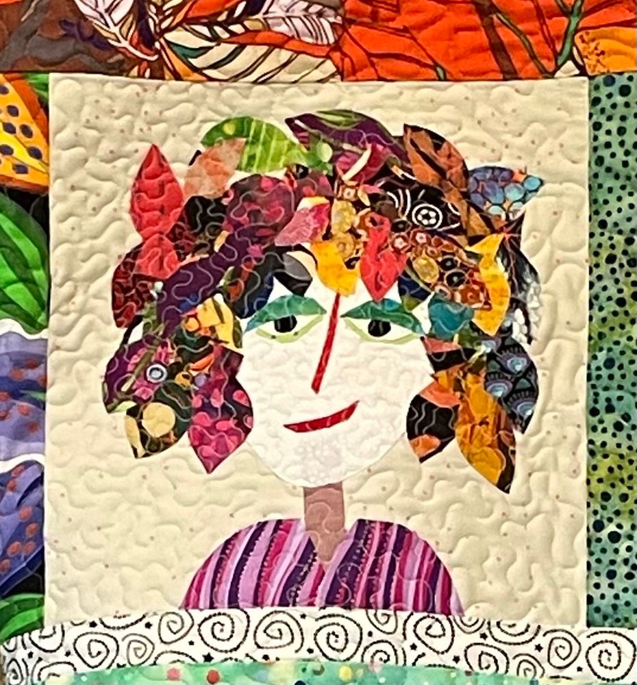 Quirky quilted face with multicolored hair and an attitude. 