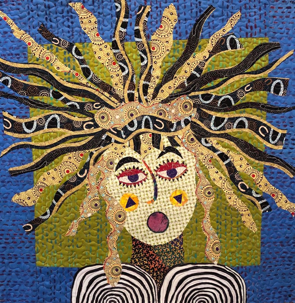 Fabric collage with blue and green background, gold and black hair, black and white breasts. Titled “Facing the Blue Sofa,” she’s all about taking risks, having fun, daring to be wild. Part of a series of slightly unhinged women.