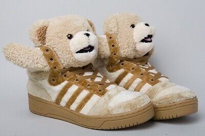 Pair of beige Adidas sneakers designed with plush teddy bears on the tongue, featuring arms sticking out to the sides.