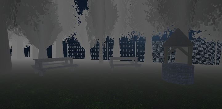 A well and two wooden benches sit in the foggy woods late one night in front of a chain link fence.