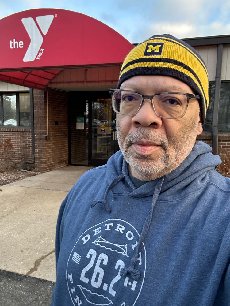 Selfie in front of a YMCA. I'm wearing a Detroit marathon hoodie and a U of M knit hat.