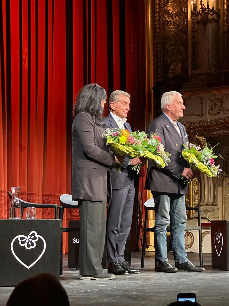 Michel Friedmann nach seiner Rede und seiner Diskussion mit Theresia Walser und Ludwig Spaenle, die mit ihm zum Schlussapplaus auf der Bühne mit Blumen in den Armen stehen.