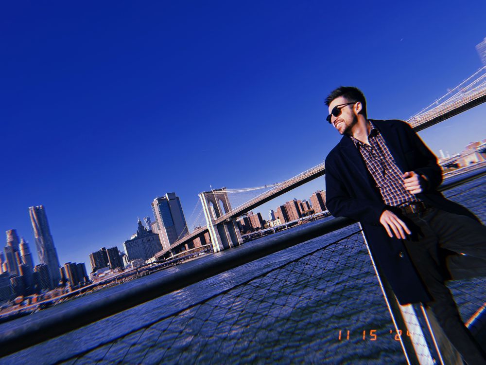 Alex posing in front of the Brooklyn Bridge in Brooklyn Bridge Park
