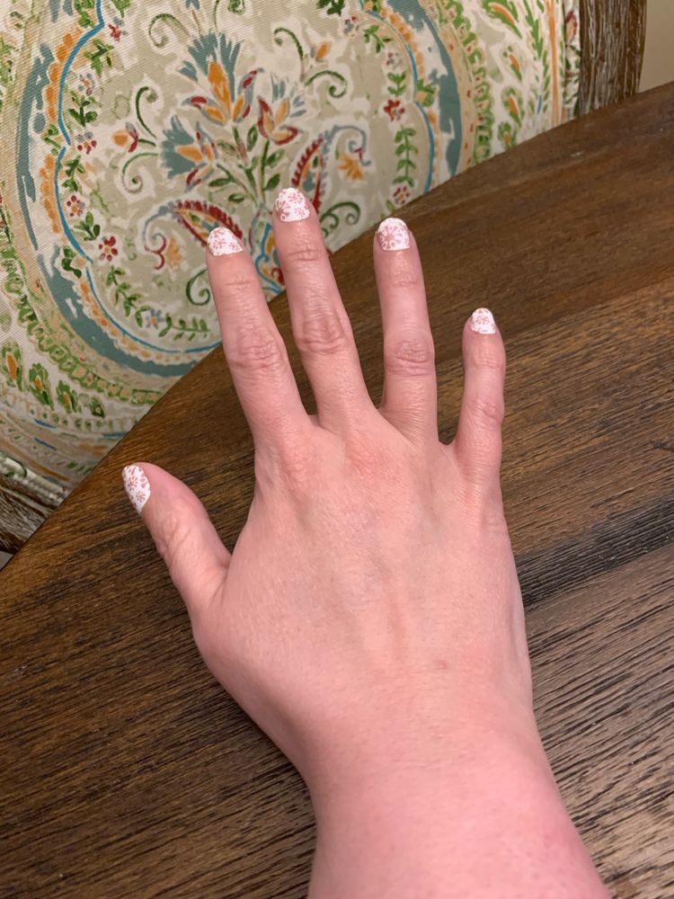 Nails decorated in mid beige design with a white background