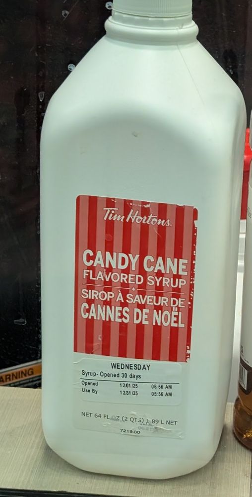 A two-quart white plastic jug labeled "Tim Hortons Candy Cane Flavored Syrup".