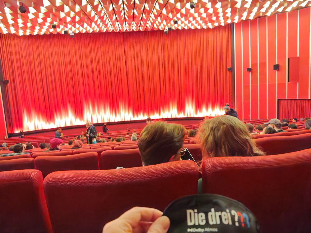 Vor mir ein sich gerade füllender großer Kinosaal, in meiner Hand eine Schlafmasken von "Die drei???"