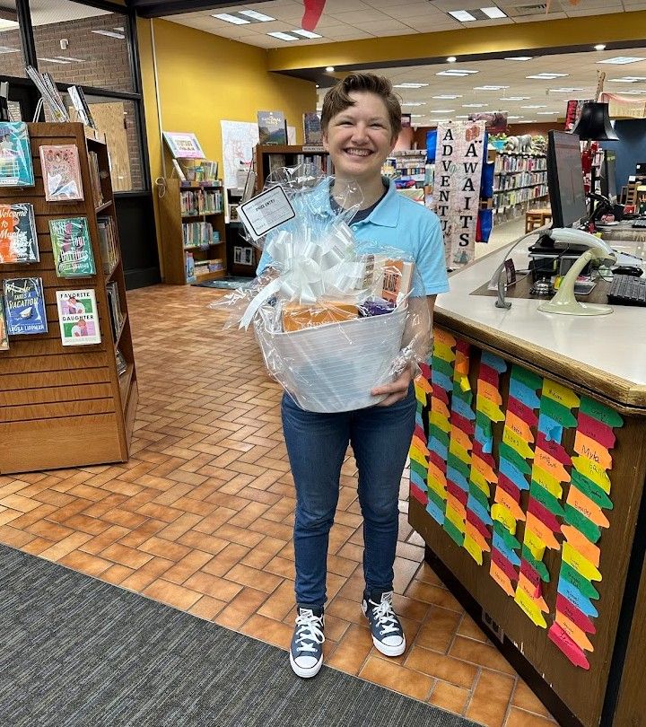 A woman holding a gift basket of prizes. 