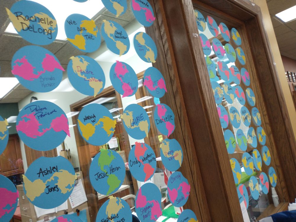 Paper worlds with names written on them displayed on interior windows.