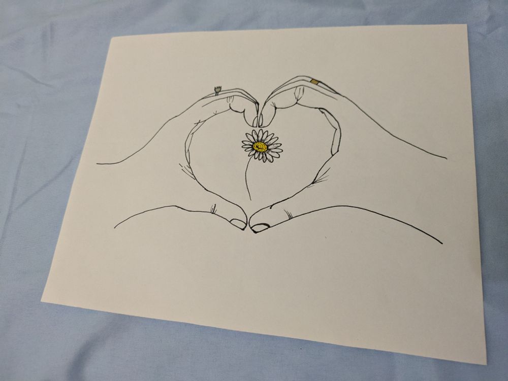Two hands cupped in a heart shape around a small white daisy. Drawn primarily in black outline with metallic accents on the wedding bands and a golden center to the daisy.