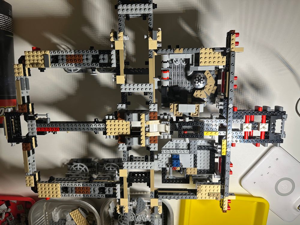 Partly built Lego set with grey, yellow, red, blue and white pieces 