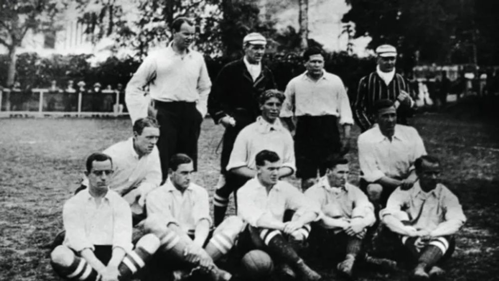 Imagem em preto e branco mostra jogadores de uma formação inicial do Corinthians, dispostos cinco em pé e seis sentados.