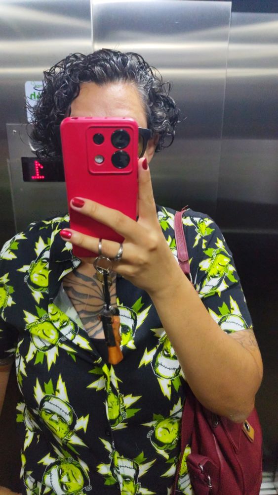 Selfie de espelho onde estou usando uma camisa de fundo preto com estampa de várias cabeças do Frankestein do Karloff.