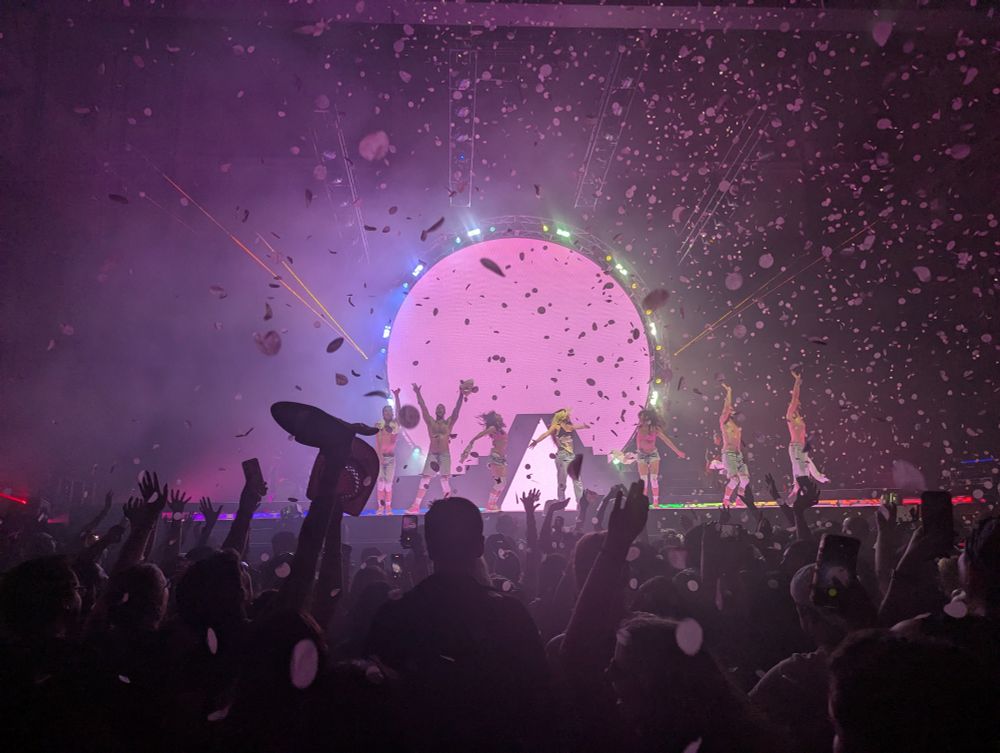 Confetti falling on a pink lit stage 