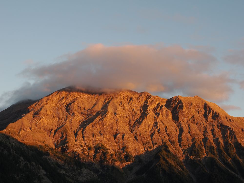 High Alpine cliffs glow red orange in the setting sun