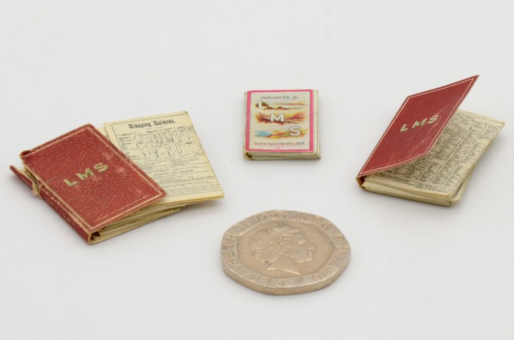 Two small timetables and a holiday guide book all labeled LMS. These are made for a dollshouse, so are very small - a 20p coin is included in the shot for scale as it is roughly the same size as the books.