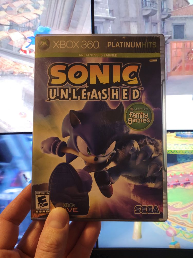 Picture of my copy of Sonic Unleashed with the game playing in the background.