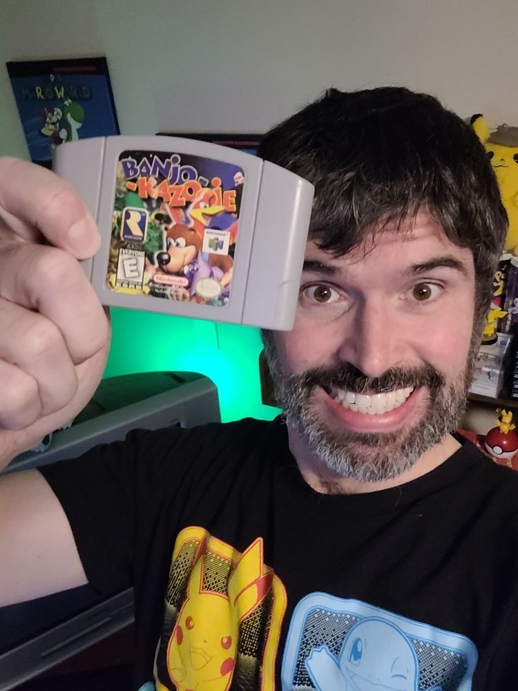 Picture of my goofy ass holding up my copy of Banjo Kazooie.