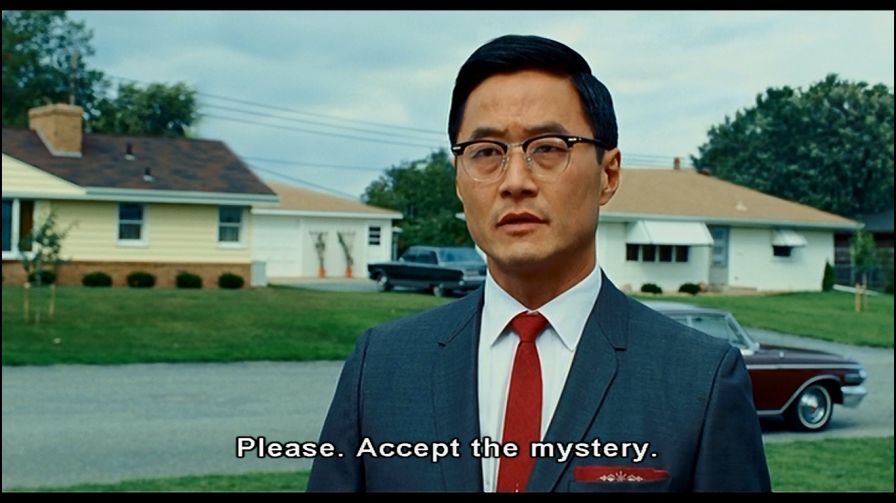 a Japanese man in a business suit saying "Please. Accept the Mystery" from "A Serious Man"