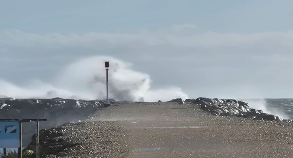 Auf dem Bild sieht man eine Bühne, die ins Meer reicht. 
Am Ende ist eine Laterne (?), hinter der die Gischt hochschlägt und sie überragt. 