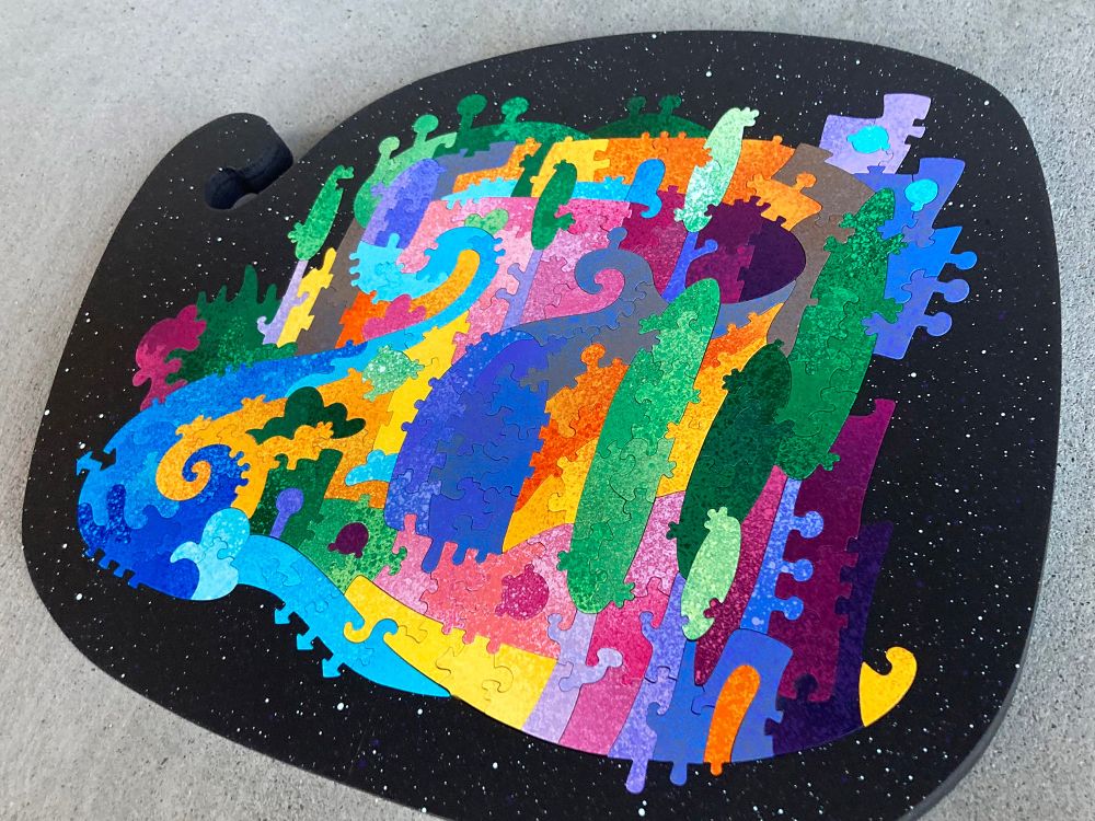 A colorful hand-cut and painted wooden jigsaw puzzle depicting a rather abstract landscape