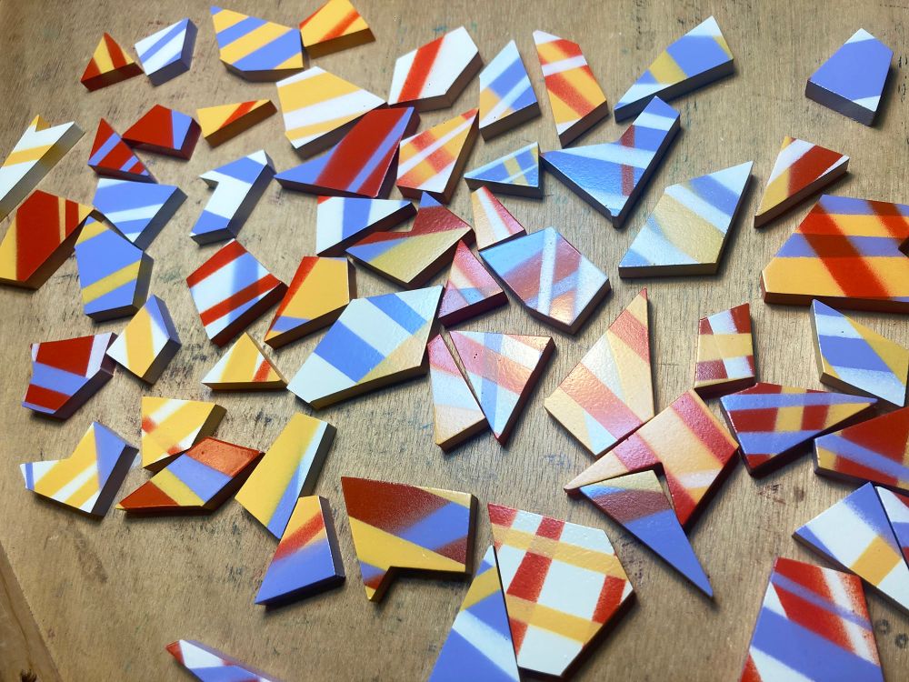 A bunch of hand-made angular wooden jigsaw puzzle pieces with no joinery, meaningless stripes, designed to infuriate anyone who attempts to assemble them