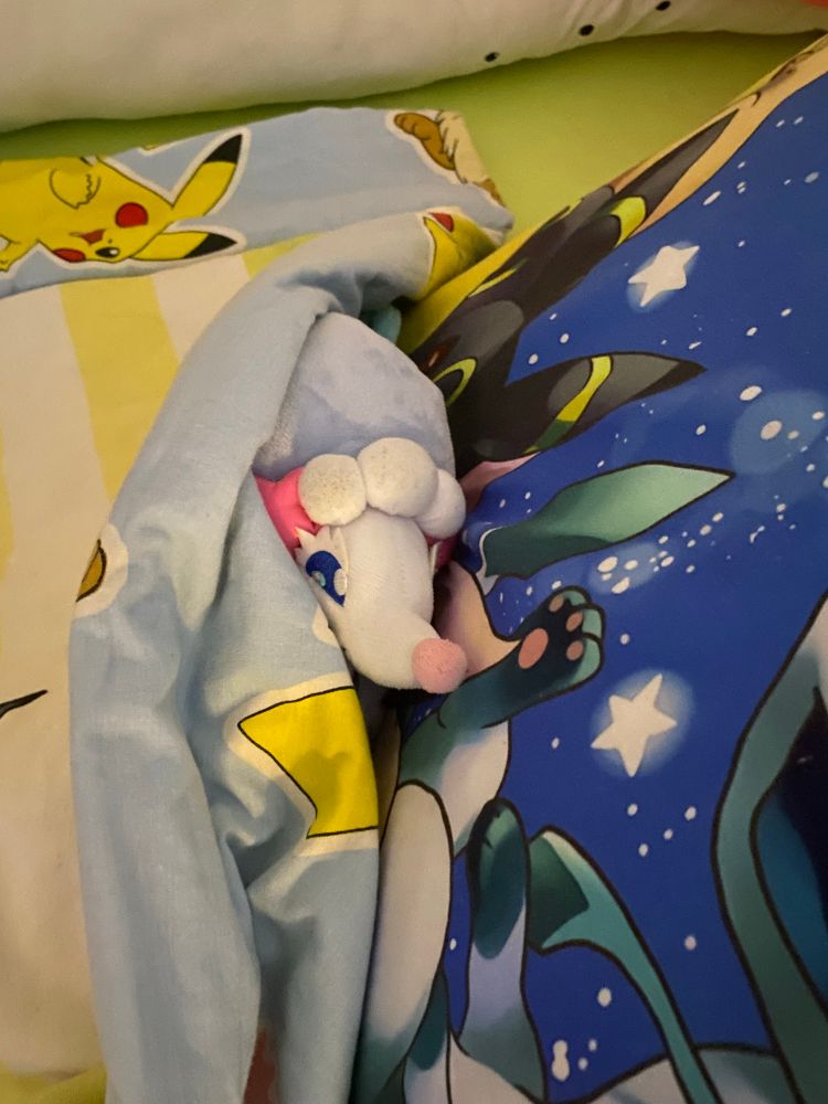 A Primarina mostly covered under a blanket, being extremely comfortable.