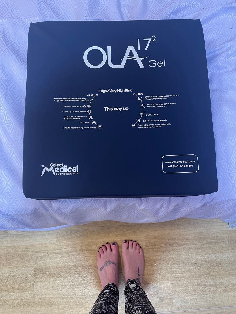 a blue square cushion pad for relieving pressure sitting on a light blue hospital bed. 