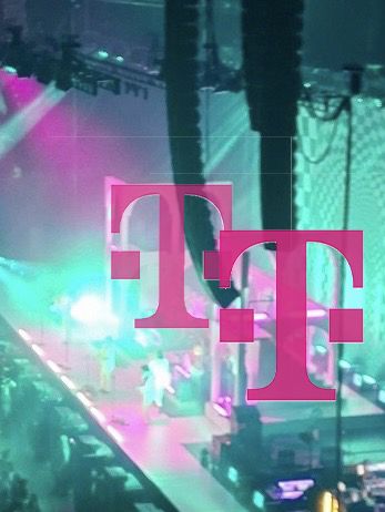 Näherer Ausschnitt des vorherigen Fotos: Bühne Olympiahalle München mit Türkiser Lichtshow und pinken Elementen. Die pinken Elemente sind jetzt Telekom Ts.