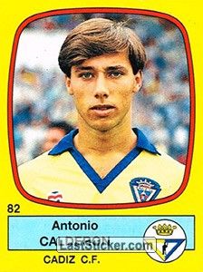 A Panini sticker of Cadiz CF player Antonio Calderon. He has a large volume of brown hair, and is wearing a yellow and blue uniform.